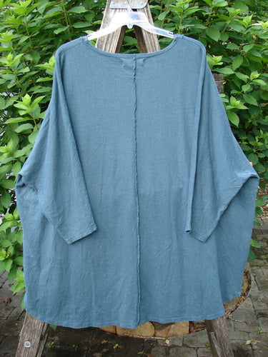 Barclay NWT Cotton Hemp Exterior Stitch Hi Low Tunic featuring dolman sleeves, curvy stitchery, and a high-low hemline on a clothes rack, showcasing a botanical theme in cozy fall fabric.