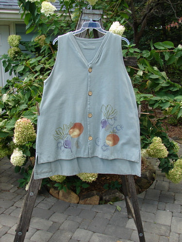 1998 Heavy Basil Vest Bountiful Harvest Birdsong OSFA displayed on a hanger outdoors, featuring a shirttail hemline, A-line shape, ribbed V-neck, shell-like buttons, signature patch, and side vents.