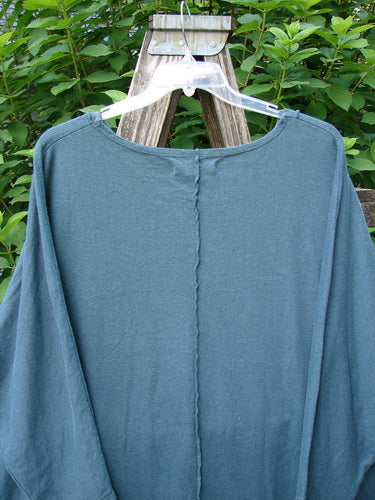 Barclay NWT Cotton Hemp Exterior Stitch Hi Low Tunic Botanical Hypnea Teal OSFA displayed on a wooden stand, featuring dolman sleeves, curvy seam details, and a unique high-low hemline.