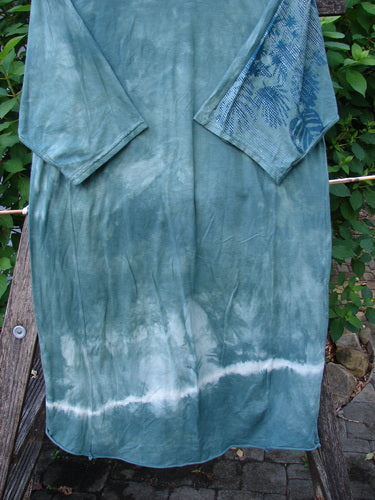 Barclay Tournesol Slim Tunic Beach Palm Mottled Green Earth OSFA, features a longer tunic length, drop shoulders, and loose three-quarter sleeves, hanging on a clothesline, showcasing its organic cotton texture.