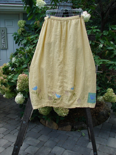 1999 Windy Day Skirt Tulip Buttercup Size 2 displayed on a clothes rack, showcasing its reverse bell shape with vertical pleats.