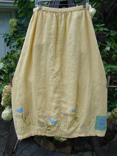 1999 Windy Day Skirt Tulip Buttercup Size 2 features a full elastic waistline, vertical pleats, and a reverse bell shape, adorned with a spring tulip pattern on lightweight handkerchief linen.