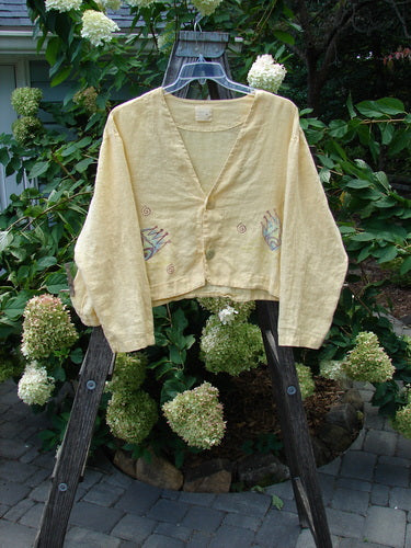 1999 Weathervane Jacket Crown Buttercup Size 2 displayed on a wooden swing, showcasing unique front buttons, a deeper V-shaped neckline, and a beautifully varying inward rounded side hem.