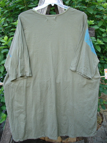 Barclay Tournesol Tunic Contour Forest Mottled Green Olive OSFA, hanging on a clothesline, features a drop shoulder, loose three-quarter sleeves, rounded neckline, and varying hemline, embodying BlueFishFinder's vintage style.