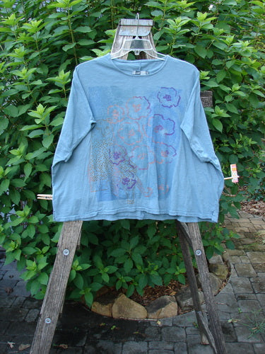 Barclay Cotton Slub Cricket Cap Sleeve Tee Camo Cat Light Teal OSFA displayed outdoors, highlighting its cap sleeves, seamless shoulders, and hip flare, embodying BlueFishFinder's vintage, expressive style.