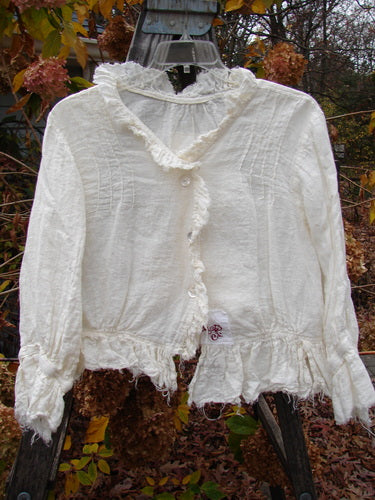 Magnolia Pearl Homespun Linen Raglan Tab Jacket in Off White on a swinger, featuring ruffled V-shaped neckline, frayed hemline, and pearl button accents, embodies Bluefishfinder.com's vintage-inspired creative expression.