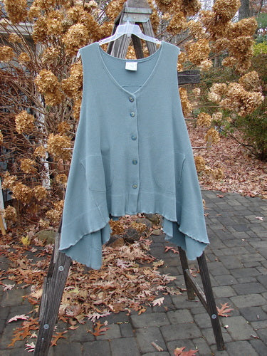 1992 Thermal Tunic Vest on wooden stand, featuring a deep V neckline, off-set rounded pockets, and a dippy sided hemline.