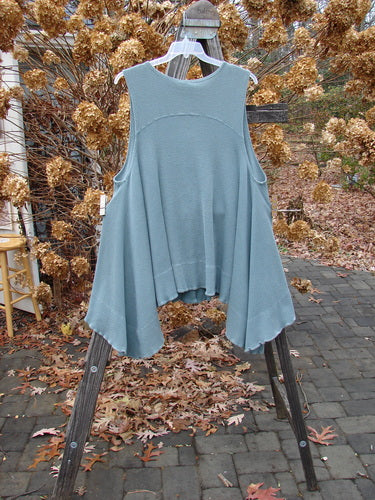 1992 Thermal Tunic Vest on rack, with blue shirt and vest, wooden stand, tablecloth