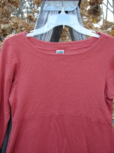 2000 Wool Pointelle Anais Top Unpainted Bittersweet Tiny Size 1: A red shirt with lettuce edging, empire waist seam, tailored waistline, and narrow lower sleeves.