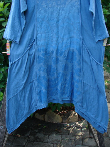 Barclay NWT Wildflower Tunic Garden Blend Blue Bird Size 0 displayed outdoors, showcasing its raw-edged front panel, flutter hemline, and exterior drop pockets, embodying Bluefishfinder.com's unique vintage style.