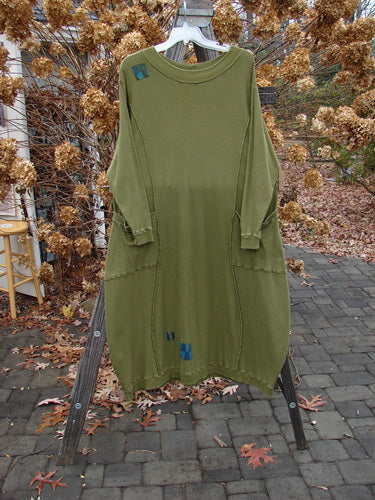 A Barclay Patched Thermal Curve Dress in Greenroot, size 1. Made from mid-weight cotton thermal. Features a unique figure-eight shape, thicker rib neckline, and exterior stitchery. Double rib top exterior pockets, hem, and lower sleeves with three signature painted patches. Measurements: Bust 50, Waist 52, Hips 54, Length 50 inches.