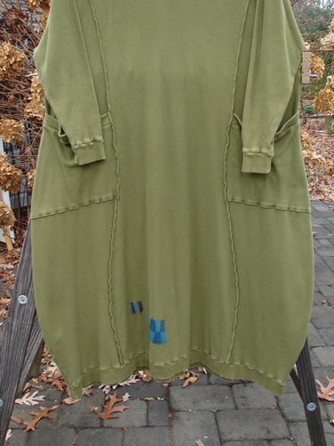 Barclay Patched Thermal Curve Dress Greenroot Size 1: A long-sleeved dress with a unique figure-eight shape and curve. Features include a thicker rib neckline, exterior stitchery, and double rib top exterior pockets. Three sweet signature painted patches adorn the dress. Bust 50, Waist 52, Hips 54, Length 50 inches. Made from mid-weight cotton thermal.