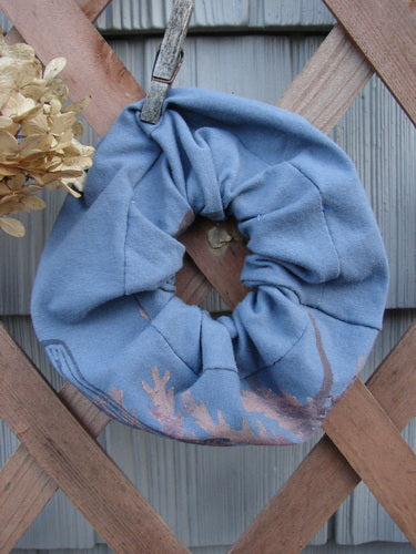 Barclay PMU Organic Cotton Hair Scrunchie Branch X Blue Dusk Extra Large on a wooden fence, showcasing its ruffled design and elastic band, crafted from sustainable vintage materials by Bluefishfinder.com.