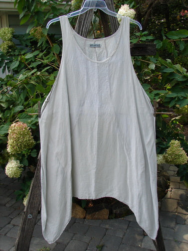 Barclay Silk Figure 8 Pinafore Unpainted Cloud Size 2 hanging on a clothesline, highlighting its unique figure-eight seams and varying hemline.