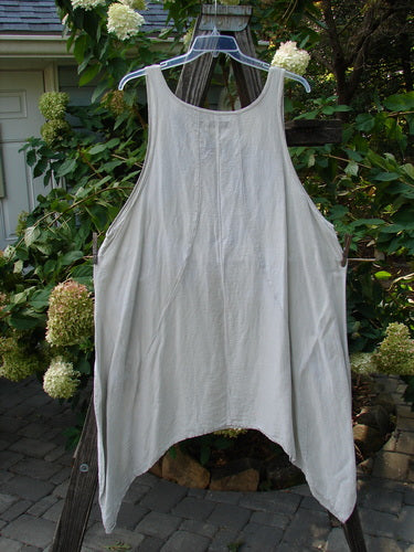 Barclay Silk Figure 8 Pinafore Unpainted Cloud Size 2 hanging on a clothesline outdoors, showcasing its unique figure-eight seams, widening front panel, and varying hemline.