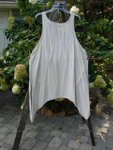 Barclay Silk Figure 8 Pinafore Unpainted Cloud Size 2 displayed on a wooden rack, showcasing its unique figure eight seams, deeper arm openings, and varying hemline.