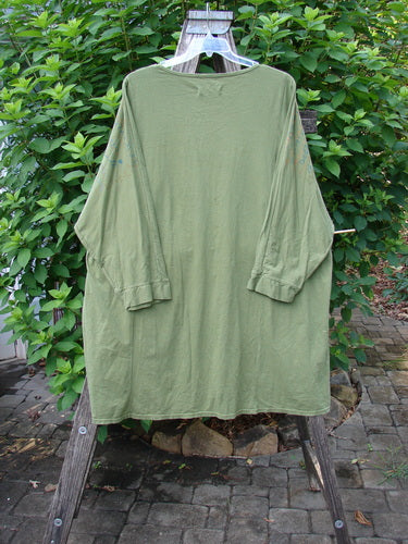 Barclay Art Tee Rose Script Mottled Peapod OSFA displayed on a wooden rack, showcasing its loose three-quarter sleeves, rounded neckline, and varying hemline, reflecting Bluefishfinder.com’s vintage-inspired style.