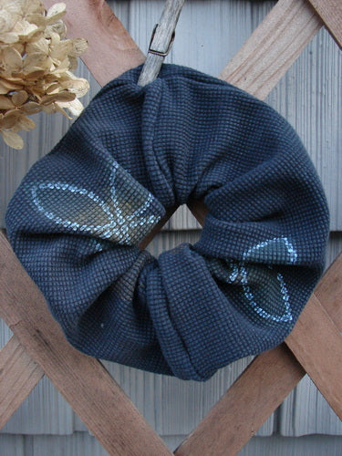 1999 PMU Thermal Hair Scrunchie Lucky Leaf Black Extra Large on a wooden fence; features ruffled fabric and thin elastic, celebrating Bluefishfinder.com's vintage-inspired sustainable fashion.