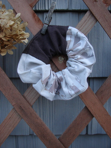 Barclay PMU Cotton & Lycra Hair Scrunchie Letter Brown Fawn Extra Large, displayed on a wooden fence, showcasing its ruffled texture and elastic band, embodying Bluefishfinder.com's vintage and sustainable fashion ethos.