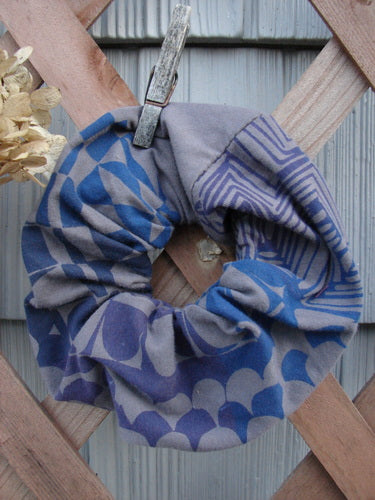 Barclay PMU Cotton & Lycra Hair Scrunchie Diamond Grid Brum Extra Large, displayed on a wooden fence, showcasing its ruffled fabric and thin elastic band, celebrating sustainable vintage designs by Jennifer Barclay.