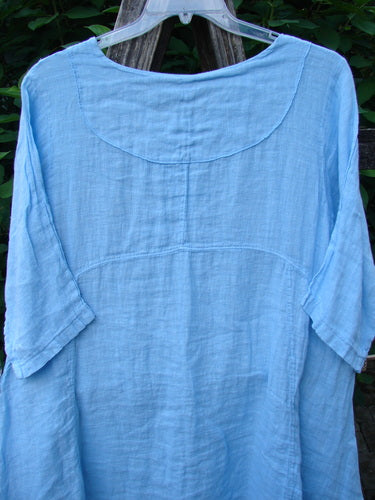 Barclay NWT Linen Cross Over Urchin Pocket Dress Unpainted Splash Size 1 features a cross-over V-neck, drop shoulders, curved empire waist, and double drop side pockets, displayed on a clothes rack.