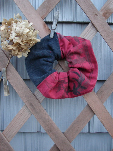 Barclay PMU Thermal Rib & Cotton Hair Scrunchie Vine Grid Black Red Extra Large displayed on a wooden fence, showcasing its ruffled fabric and elastic band, embodying Bluefishfinder.com's vintage, sustainable fashion ethos.