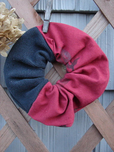 Barclay PMU Thermal Rib & Cotton Hair Scrunchie Vine Grid Black Red Extra Large displayed on a rustic wooden fence, highlighting its ruffled fabric and soft, forgiving texture in a sustainable vintage design.