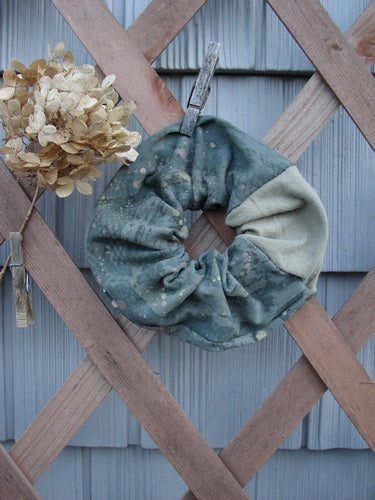 Barclay PMU Cotton & Lycra Hair Scrunchie Rain Pond Green Extra Large displayed on a wooden fence, showcasing its ruffled fabric and durable elastic band, embodying sustainable vintage design by Bluefishfinder.com.