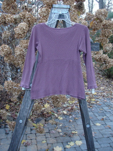 2000 Wool Pointelle Anais Top Unpainted Murple Tiny Size 0: A close-up of a purple shirt on a wooden rack.