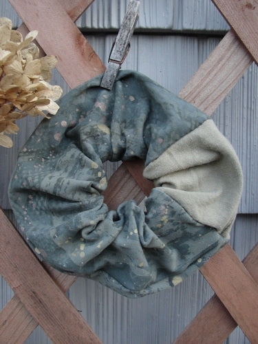 Barclay PMU Cotton & Lycra Hair Scrunchie Rain Pond Green Extra Large, displayed on a wooden fence, showcasing its ruffled fabric and elastic band, exemplifying Bluefishfinder's sustainable vintage-inspired design.