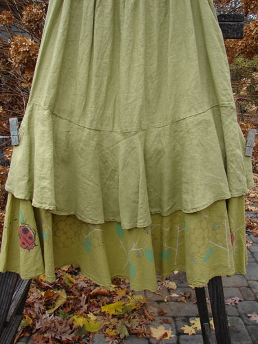 Barclay Linen Two Tier Ruffle Skirt Ladybug Yellow Olive Size 2, featuring a thinner elastic waistline, wider spinning double A-line fall, and a lower batiste ruffle with a tiny leaf pattern.