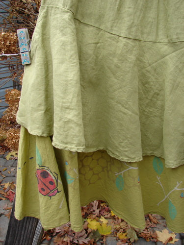 Barclay Linen Two Tier Ruffle Skirt with ladybug motif, in Yellow Olive. Medium weight linen upper layer and painted batiste lower layer. Elastic waistline, double lined fall, and huge lower batiste ruffle. Perfect for layering or wearing alone. Size 2.