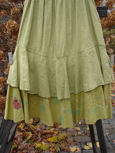 Barclay Linen Two Tier Ruffle Skirt with ladybug motif, in Yellow Olive. Medium weight linen upper layer and painted batiste lower layer. Elastic waistline, double lined fall, huge lower batiste ruffle. Perfect for layering or wearing alone. Size 2.