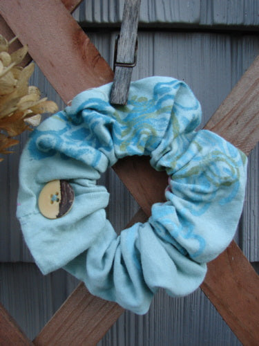 Barclay PMU Organic Cotton Button Hair Scrunchie Abstract Green Pink Medium, featuring a blue ruffled design with a central button, showcasing sustainable vintage style by Jennifer Barclay at Bluefishfinder.com.