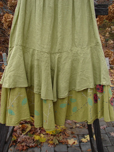 Barclay Linen Two Tier Ruffle Skirt Ladybug Yellow Olive Size 2 with floral design, featuring a thinner elastic waistline, double A-line fall, and large lower ruffle with tiny leaf pattern.