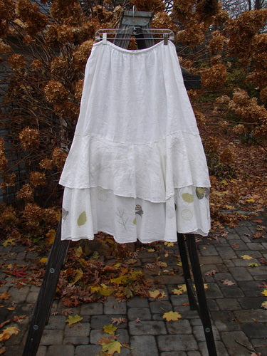 A Barclay Linen Two Tier Ruffle Skirt, featuring a white skirt with ruffles. Perfect for layering or wearing alone. Size 2.
