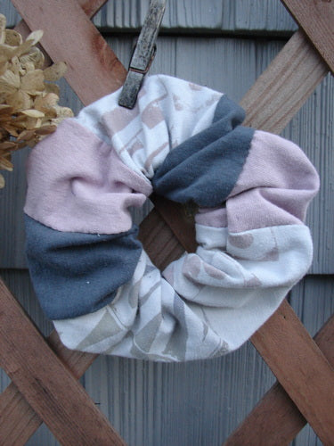 Barclay PMU Cotton & Lycra Hair Scrunchie Letter Brown Fawn Pink Extra Large displayed on a wooden fence, showcasing its ruffled fabric and thin elastic band, embodying Bluefishfinder.com's vintage sustainability ethos.