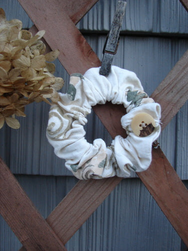 1994 PMU Cotton Button Hair Scrunchie Floral Tea Dye Large, displayed on a wooden fence, showcasing its ruffled fabric, button detail, and soft, sustainable design from Bluefishfinder.com's vintage-inspired collection.