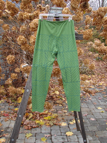 A slim legging with a continuous pine forest design hanging on a clothesline.