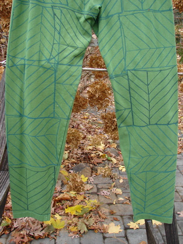 A pair of slim legging trousers with a continuous pine forest pattern.