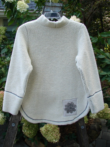 2000 PMU Fleece Pullover High Back Chair Natural Size 0, featuring a flower patch on the front, rounded hemline, vented sides, and a kangaroo pocket, displayed on a hanger.