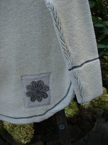 Close-up of the 2000 PMU Fleece Pullover High Back Chair Natural Size 0, showcasing a detailed sweater patch and pocket patch, exterior contrast stitching, and a kangaroo front pocket.