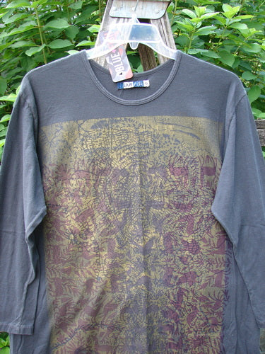 Barclay NWT Long Sleeved Studio Tee Metallic Forest Life Shadow Size 0 displayed on a wooden swinger, showcasing its long cozy sleeves, rounded neckline, and metallic forest theme, highlighting its organic cotton material.