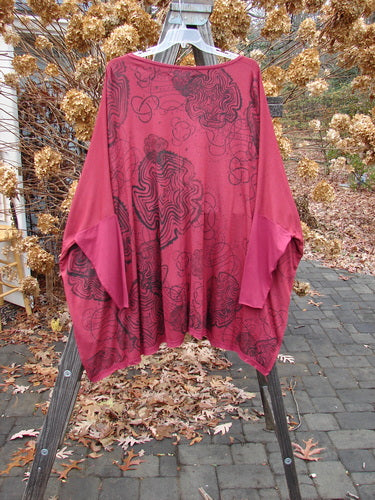 Barclay NWT Celebration Cardigan with spirograph design, flutter hem, and dolman sleeves on a rack.
