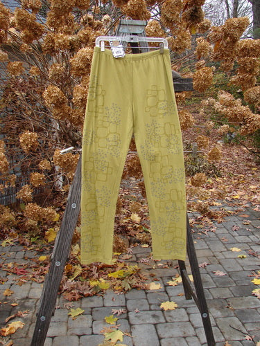 A pair of Barclay NWT Cotton Lycra relaxed leggings, size 2, hanging on a rack outdoors amidst autumn trees.