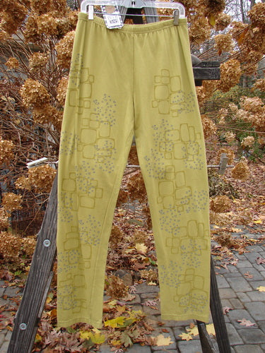 A pair of yellow pants with grey designs, featuring a relaxed legging style. Barclay NWT Cotton Lycra Relaxed Legging Star Path Green Olive Size 2.