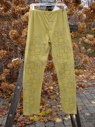A pair of relaxed leggings with a star path design in green olive, size 2.