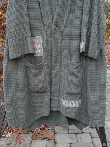 2001 Patched Toy Box Jacket Abstract Kelp Size 1: A long grey coat with pockets, woven in patterns of raised cording. Features a deeper neckline, vintage button closure, and oversized front lower pockets. Includes sewn-on colorful patches and a magnificent interior floral blue fish signature patch. Bust 54, waist 56, hips 60, hem circumference 85. Front length 44, back length 52 inches.