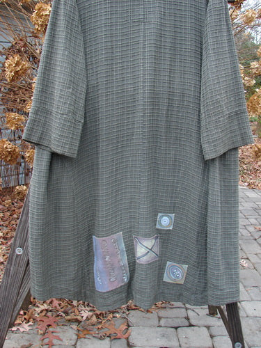2001 Patched Toy Box Jacket Abstract Kelp Size 1: A long grey dress with a patchwork design, featuring raised cording patterns and colorful patches.
