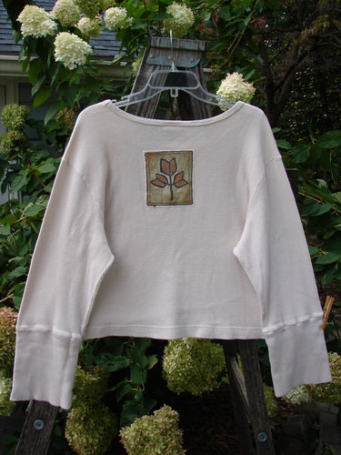 Barclay PMU Patched Thermal Galway Top Natural Size 1 featuring a white sweater with a flower patch, ribbed lower sleeve accents, rounded neckline, and cropped length.